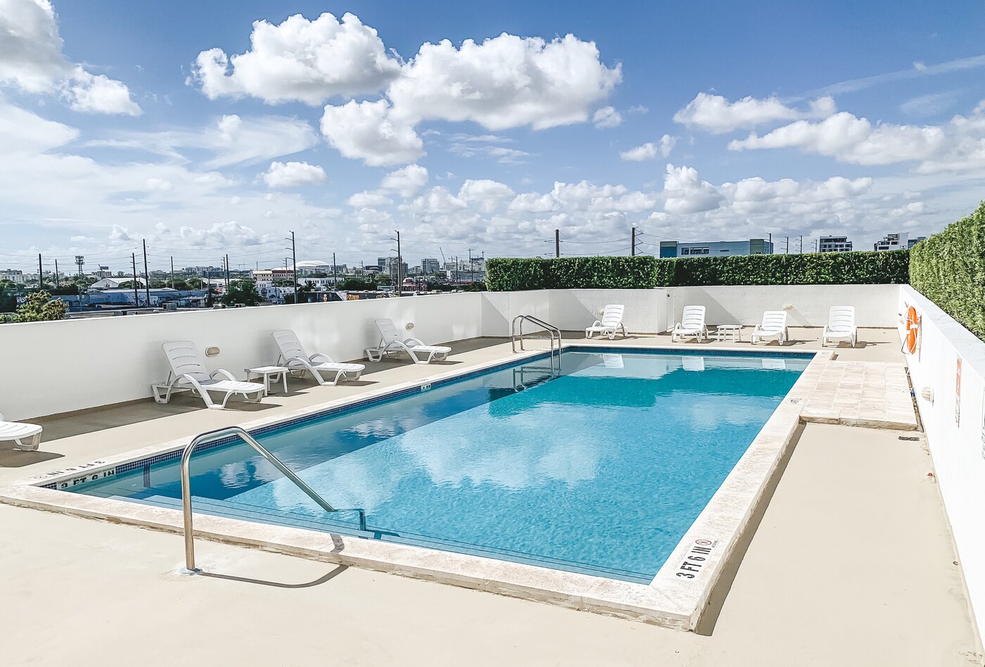 Pool deck with lounge chairs and city views